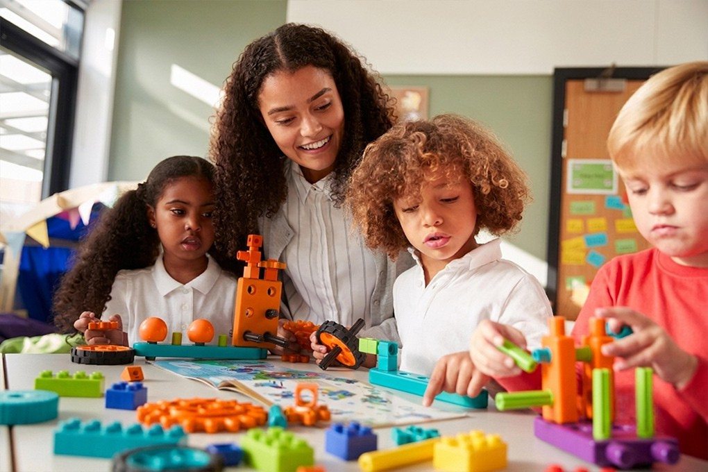 Early Childhood Assistant guiding children through a creative activity
